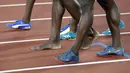 Usain Bolt (tengah) berjalan tanpa mengenakan sepatu usai mengikuti nomor lari estafet 4x100m putra di World Athletics Championships, London (12/8/2017). (AP/Matthias Schrader)