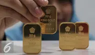 Petugas menunjukan emas batangan di kantor BNI Syariah, Jakarta, Senin (30/11). Harga jual-beli kembali (buyback) emas Antam turun Rp 1.000 usai akhir pekan kemarin naik di tengah turunnya harga emas global. (Liputan6.com/Angga Yuniar)