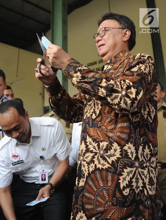 Mendagri Tjahjo Kumolo mengunting E-KTP di gudang penyimpanan barang inventarisasi Kemendagri di Jalan Raya Parung, Kab Bogor (30/5). Tjahjo melihat kondisi gudang pasca-insiden tercecernya E-KTP di jalan raya Selabenda Bogor. (Merdeka.com/Arie Basuki)
