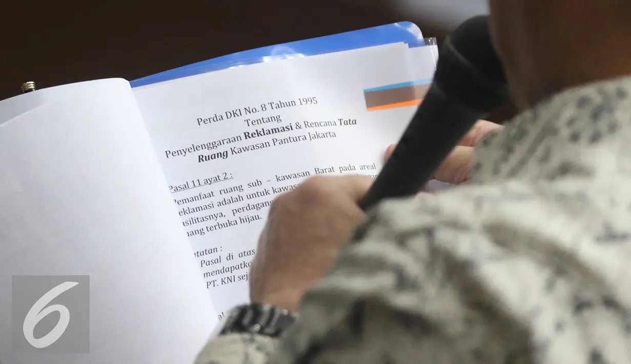 Aguan membaca Perda DKI tentang penyelenggaraan Reklamasi saat memberi keterangan di Pengadilan Tipikor terkait kasus suap pembahasan Raperda tentang Reklamasi Pantai Utara Jakarta, Rabu (27/7). (Liputan6.com/ Immanuel Antonius)