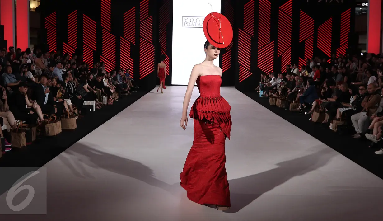 Seorang model membawakan busana rancangan teranyar Yogie Pratama pada malam pembukaan Senayan City Fashion Nation ke-11, Kamis (6/4). Yogie menampilkan 'Scarlet', sebuah koleksi deluxe ready to wear yang serba merah. (Liputan6.com/Herman Zakharia)