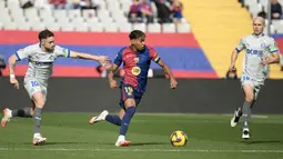 Pemain Barcelona, Lamine Yamal menggiring bola melewati penjagaan dari sejumlah pemain Deportivo Alaves dalam laga lanjutan Liga Spanyol 2024/2025 di Estadi Olimpic Lluis Companys, Barcelona, Spanyol, Minggu (02/02/2025) waktu setempat. (AFP/Josep Lago)