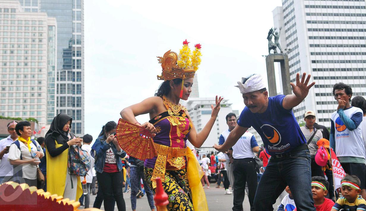 Penari menampilkan seni Tari Pendet khas Bali dalam parade kebudayaan bertajuk 'Kita Indonesia' di kawasan Bundaran HI, Jakarta, Minggu (4/12). Para peserta Parade Kebudayaan tampak antusias menyaksikan tarian itu. (Liputan6.com/Angga Yuniar)
