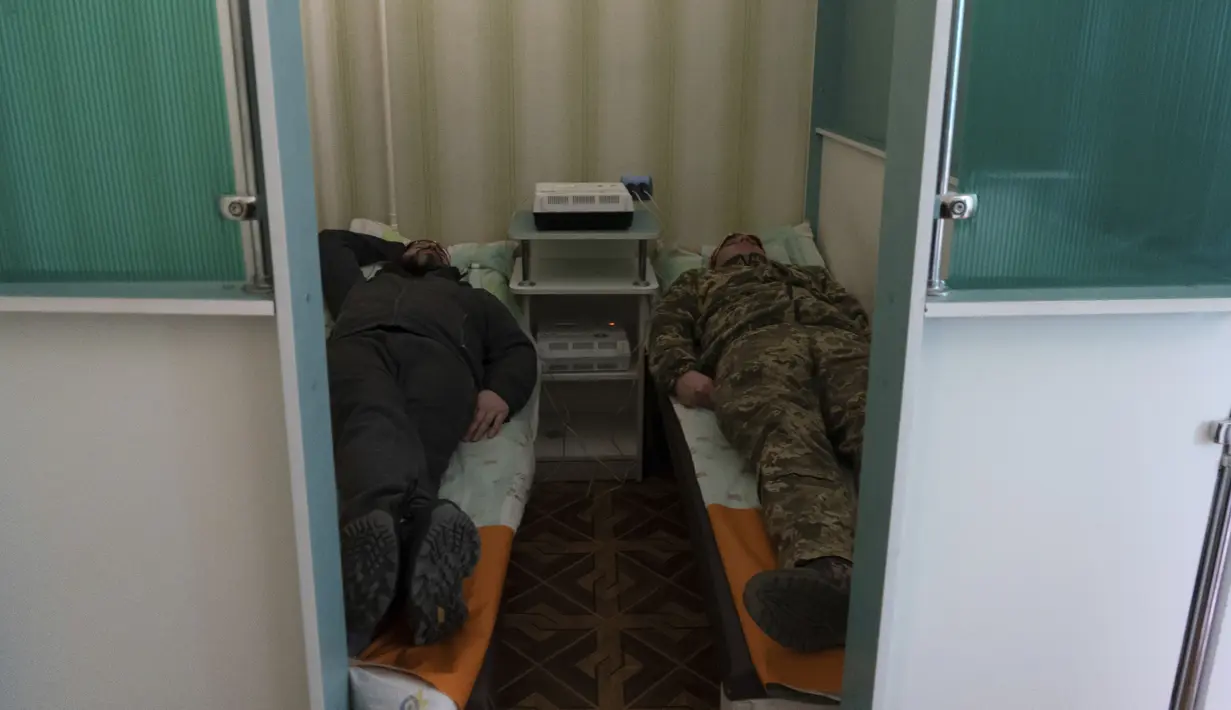 Tentara Ukraina berbaring selama sesi terapi electrosleep di pusat rehabilitasi di wilayah Kharkiv, pada 30 Desember 2022. Perang 10 bulan tanpa henti telah mendorong seorang komandan setempat untuk mengubah sanatorium era soviet lama menjadi pusat pemulihan bagi prajurit untuk mengobati penyakit mental dan fisik. (AP Photo/Vasilisa Stepanenko)