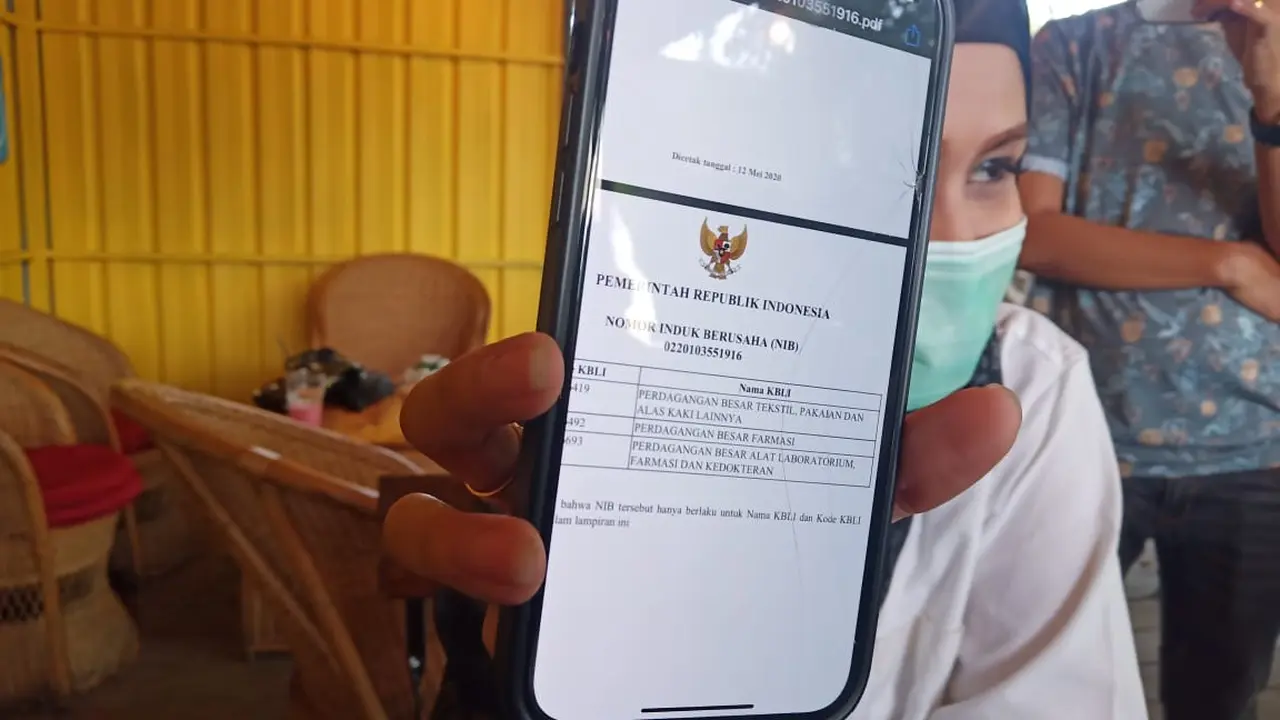 Pemilik Perusahaan Batik Tanah Liek Pusako Mande menunjukkan izin usaha pengadaan alat kesehatan. (Liputan6.com/ Novia Harlina)