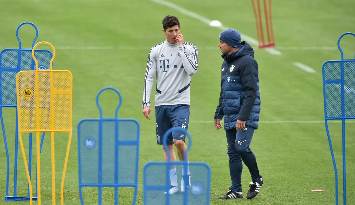 Pelatih Bayern Munchen Hansi Flick (kanan) berbincang dengan pemainnya Robert Lewandowski saat sesi latihan di Munich, Jerman, Selasa (5/5/2020). Bundesliga direncanakan kembali bergulir setelah otoritas setempat mulai melonggarkan lockdown untuk pencegahan penyebaran COVID-19. (Christof STACHE/AFP)