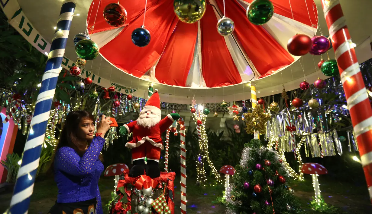 Seorang pengunjung memotret dekorasi Natal dengan telepon seluler di Yangon, Myanmar (10/12/2020). Berbagai dekorasi hingga akseoris dipasang untuk menyambut Natal di kota tersebut. (Xinhua/U Aung)