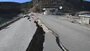 Retakan besar terlihat di jalan dekat pusat gempa, di distrik Pazarcik, kota Kahramanmaras, Turki pada Kamis 16 Februari 2023 setelah terjadinya gempa berkekuatan 7,8 magnitudo menghantam beberapa wilayah di Turki dan Suriah pada 6 Februari lalu. (OZAN KOSE/AFP)