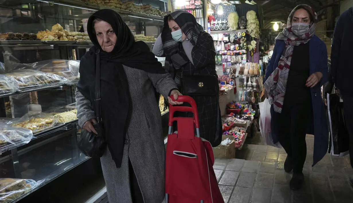 Orang-orang berjalan di bazaar bersejarah tua Teheran, Iran, Minggu (26/2/2023). Beberapa hari terakhir ini antrean panjang tampak di kantor-kantor penukaran mata uang karena banyaknya warga yang berupaya mendapatkan mata uang dolar yang semakin langka. (AP Photo/Vahid Salemi)