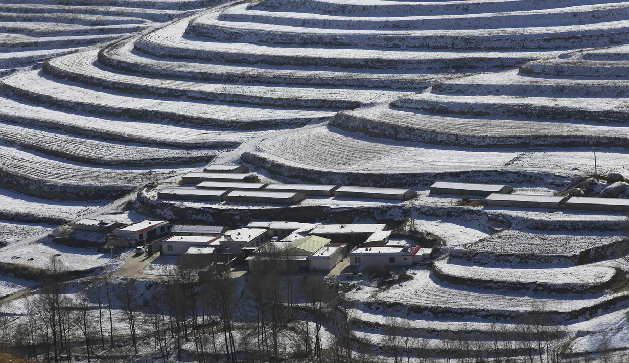 Foto dari udara yang diabadikan pada 7 Desember 2020 ini menunjukkan pemandangan sawah terasering yang tertutup salju di Kota Wuwei, Wilayah Otonom Etnis Tibet Tianzhu, Provinsi Gansu, China barat laut. (Xinhua/Jiang Aiping)
