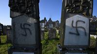 Lambang swastika Nazi pada nisan di pemakaman Yahudi, Westhoffen, dekat Strasbourg, Prancis, Rabu (4/12/2019). Sedikitnya 107 makam menjadi sasaran vandalisme dengan dicoreti lambang swastika Nazi. (AFP/Patrick Hertzog)