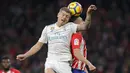 Gelandang Real Madrid, Toni Kroos, duel udara dengan gelandang Atletico Madrid, Saul Niguez, pada laga La Liga di Stadion Metropolitano, Sabtu (18/11/2017). Derbi Madrid tersebut berakhir dengan skor 0-0. (AP/Paul White)