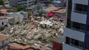 Petugas penyelamat menggali tumpukan puing-puing setelah sebuah bangunan runtuh di Fortaleza, negara bagian Ceara, Brasil, Selasa (15/10/2019). Pejalan kaki yang tengah melewati gedung ketika runtuh juga dibawa ke klinik medis terdekat. (RODRIGO PATROCINIO / AFP)