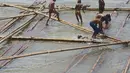 Anak-anak bermain air di atas batang kayu bekas dermaga sandar kapal tradisional di Kawasan Cilincing, Jakarta, Selasa (10/4). Aktifitas bermain laut di pesisir pantai teluk Jakarta ini menjadi keseharian mereka sepeluang sekolah.(Merdeka.com/Imam Buhori)
