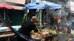 Pedagang memindahkan barang dagangannya di dari lokasi kebakaran di Pasar Kebayoran Lama, Jakarta, Selasa (13/6). Kebakaran yang melanda ruko tersebut belum diketahui penyebabnya. (Liputan6.com/Johan Tallo)