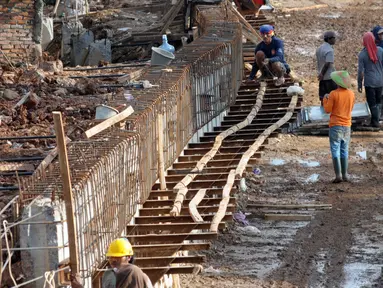 Sejumlah Pekerja memasang Kawat besi dan beton Tanggul di Pinggiran kali ciliwung, Kalibata, Jakarta, Sabtu (2/4) Pemasangan beton tanggul tersebut untuk meminimalisir banjir kiriman yang sering terjadi di kawasan tersebut. (Liputa6.com/Helmi Afandi)