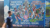 Warga melintasi mural pemilu di Jalan Karet, Depok, Jawa Barat, Rabu (20/3). Mural tersebut mengajak masyarakat untuk berpartisipasi dalam menyukseskan pemilu dengan cara damai dan menjaga meski berbeda pilihan. (Liputan6.com/Herman Zakharia)