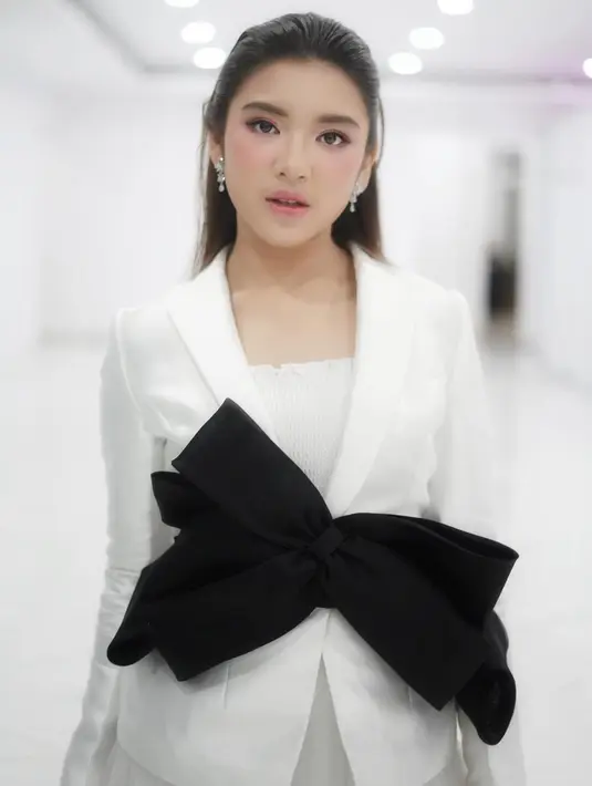 Tampil serba putih dengan dress formal berwarna putih, gaya Tiara Andini begitu memesona. Dengan tambahan pita berwarna hitam di bajunya, membuat penampilan Tiara makin stylish. (Liputan6.com/IG/@tiaraandini)