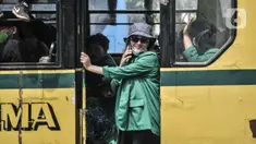 Mahasiswi berada di bus saat mengikuti aksi menolak UU Cipta Kerja di kawasan Patung Kuda, Jakarta, Selasa (20/10/2020). Puluhan mahasiswi turut menghiasi aksi menolak UU Cipta Kerja yang diikuti oleh buruh, mahasiswa, dan pelajar. (merdeka.com/Iqbal S. Nugroho)
