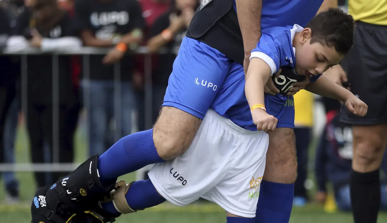 Seorang anak berkebutuhan khusus, Vinicius dan pesepakbola Brasil junior, Dutra menendang bola saat acara "World Boots" di Neymar Institute, Brasil, 7 Juni 2015.(REUTERS/Paulo Whitaker)