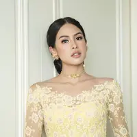 Penambahan kalung, anting, dan hiasan rambut emas menambah kesan glamor.