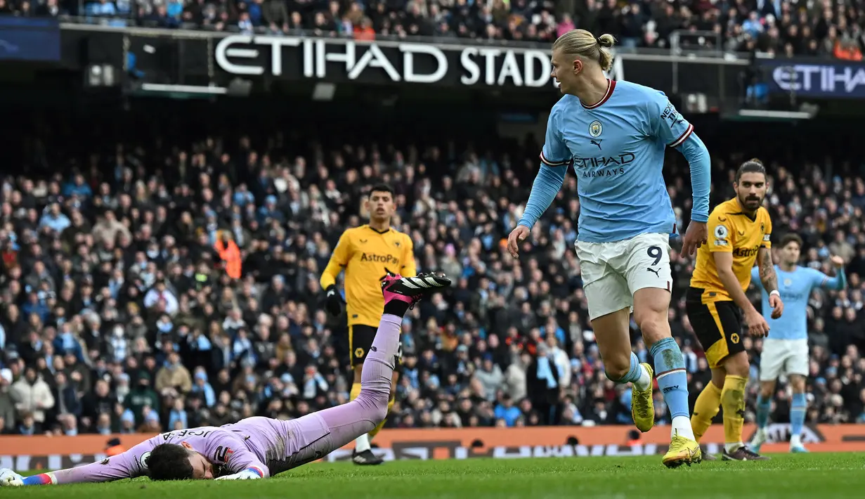Pemain Manchester City, Erling Haaland mencetak gol ketiga timnya ke gawang Wolves saat laga lanjutan Liga Inggris 2022/2023 yang berlangsung di Etihad Stadium, Manchester, Minggu (22/01/2023) dini hari WIB. Haaland berhasil melesatkan empat hattrick dalam 19 laga di Liga Inggris. (AFP/Paul Ellis)