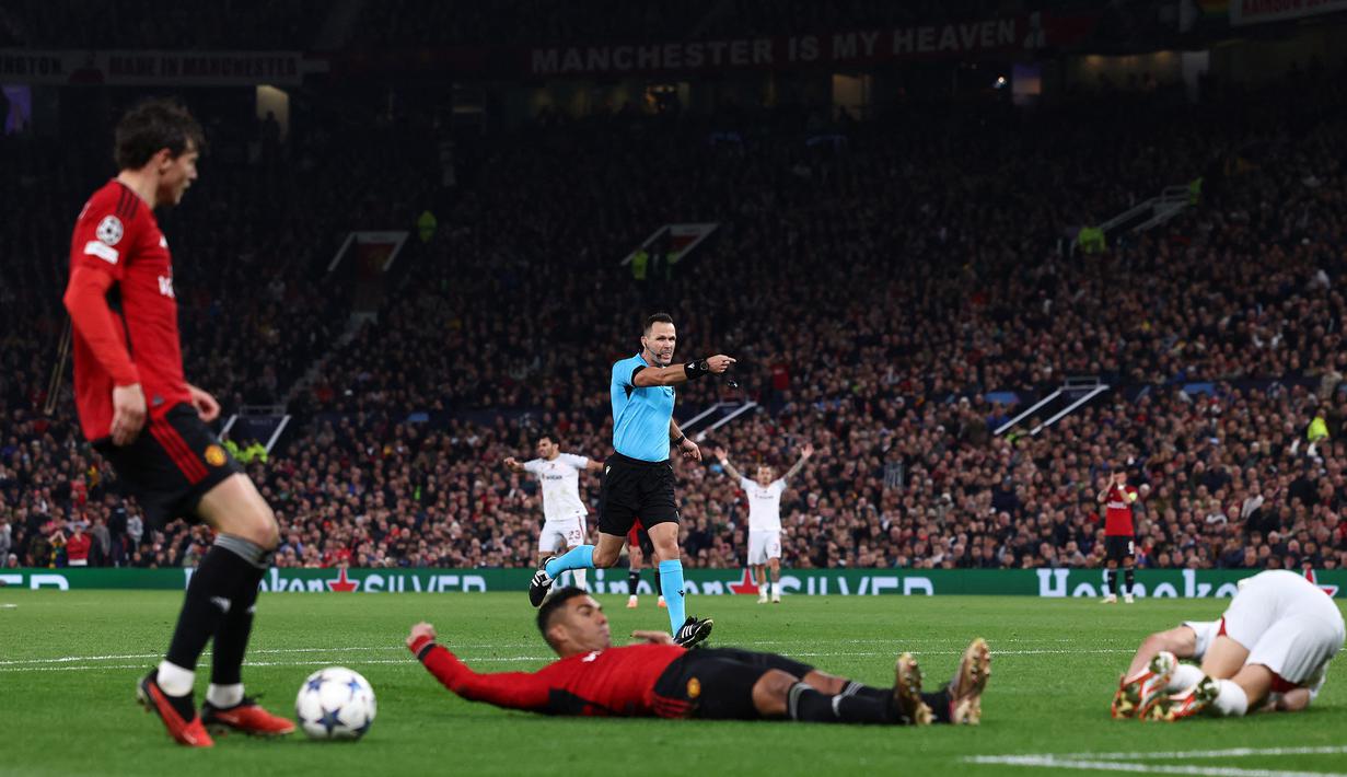 Wasit Ivan Kruzliak (tengah), menunjuk titik putih setelah pemain MU, Casemiro (tengah bawah), melakukan pelanggran kepada pemain Galatasaray dalam pertandingan lanjutan Grup A Liga Champions 2023/2024 yang berlangsung di Old Trafford, Manchester, Rabu (4/10/2023) dini hari WIB. Dalam pertandingan tersebut MU harus menelan kekalahan 2-3 dari Galatasaray. (AFP/Darren Staples)