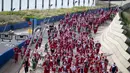 Sejumlah pelari berkostum Sinterklas berlomba dalam acara fun run 5 km di jalanan Barcelona, Spanyol pada Minggu (22/12/2024) waktu setempat. (AFP/Josep Lago)