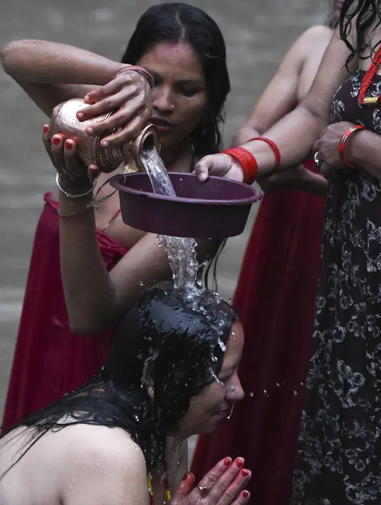 Wanita Hindu Nepal mandi suci di sungai Bagmati selama festival Rishi Panchami di Kathmandu (3/9/2019). Dalam festival Rishi Panchami, wanita yang belum menikah menginginkan suami yang tampan dan menikah dengan bahagia. (AFP Photo/Prakash Mathema)