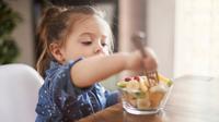 Anak perempuan yang ingin memakan buah-buahan yang sudah dipotongi orangtuanya (Foto dok : Freepik/gpointstudio).