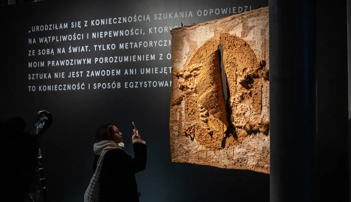 Seorang gadis melihat 'Abakan' - kain tenun yang merupakan bagian dari pameran Magdalena Abakanowicz di rumah lelang Desa Unicum di Warsawa, Polandia, pada 21 November 2023. (Wojtek Radwanski / AFP)
