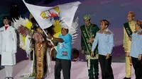 Gubernur Papua, Lukas Enembe, menerima bendera PON dalam pesta penutupan di Stadion Gelora Bandung Lautan Api, Bandung, Kamis (29/9/2016). (Bola.com/Vitalis Yogi Trisna)