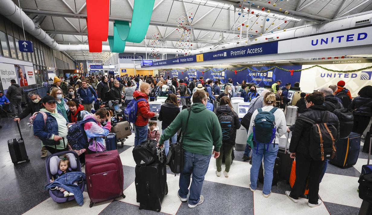 Pelancong mengantre untuk check-in penerbangan di Terminal 1 United Airlines menjelang Liburan Natal di Bandara Internasional O'Hare di Chicago (22/12/2022). Lebih dari 1.500 penerbangan dibatalkan di seluruh AS pada Kamis pagi karena badai musim dingin yang dahsyat membalikkan rencana perjalanan liburan dengan ancaman tiga kali lipat dari salju tebal, angin menderu, dan dingin yang menggigit. (AFP/Kamil Krzaczynski)