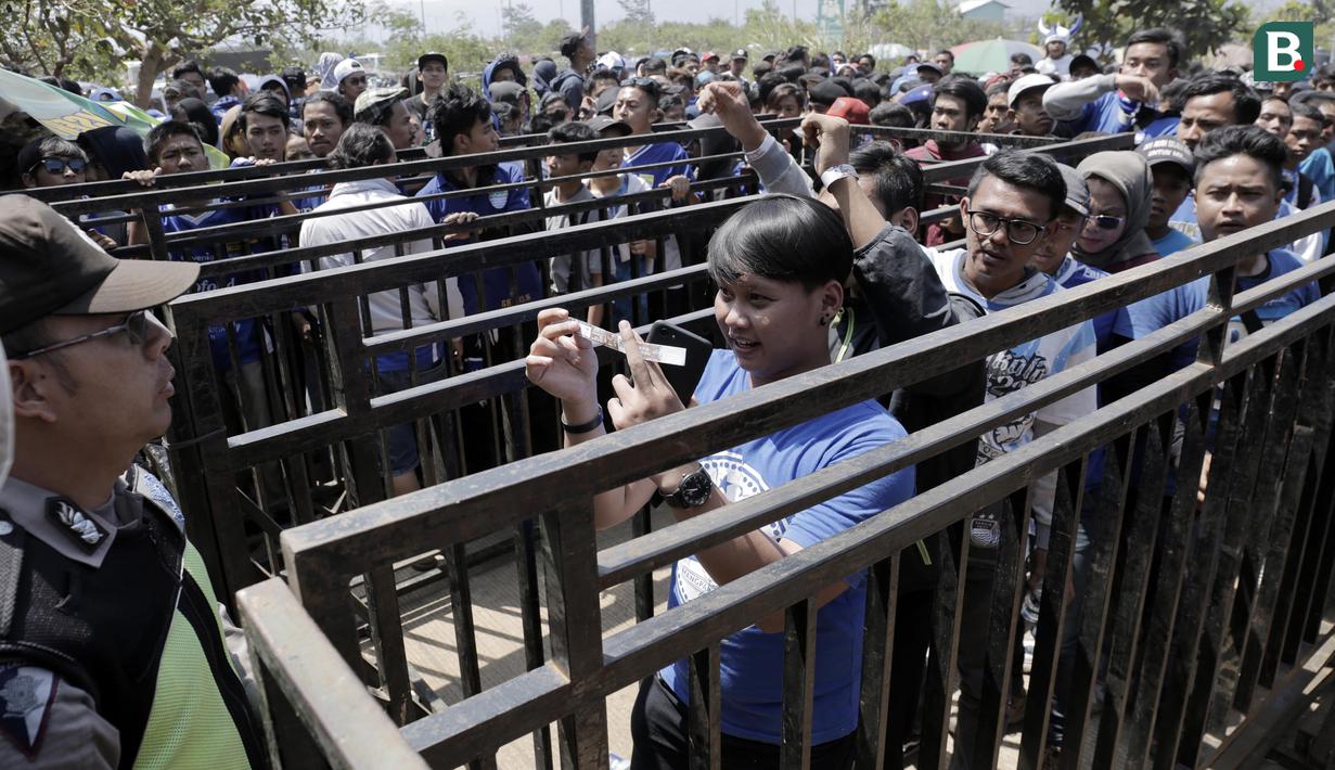 Suporter menunjukan tiket di gerbang masuk Stadion GBLA, Jawa Barat, Minggu (23/9/2018). Pengamanan jelang laga Persib Bandung kontra Persija Jakarta diperketat. (Bola.com/M Iqbal Ichsan)