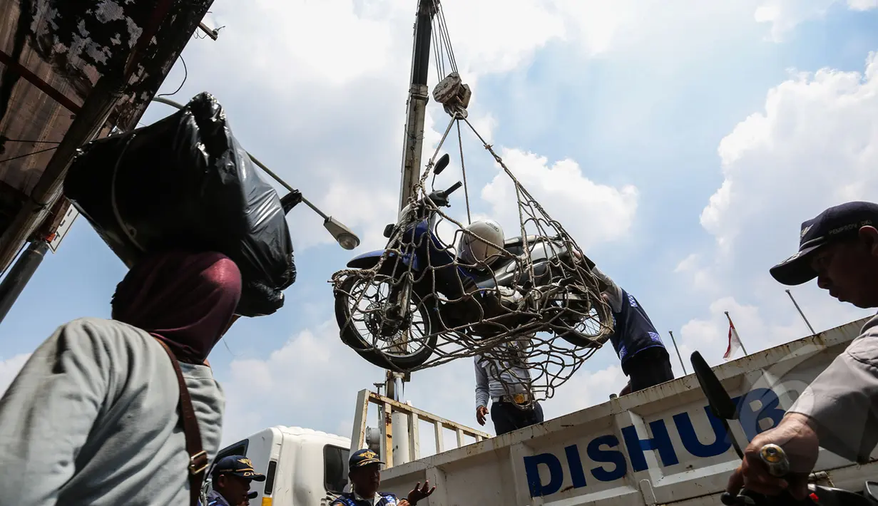 Petugas Dinas Perhubungan merazia parkir liar motor dengan menggunakan jaring di kawasan Pasar Tanah Abang, Jakarta, Kamis (16/4/2015). Razia dilakukan untuk menciptakan kawasan yang tertib serta nyaman di kawasan Tanah Abang. (Liputan6.com/Faizal Fanani)