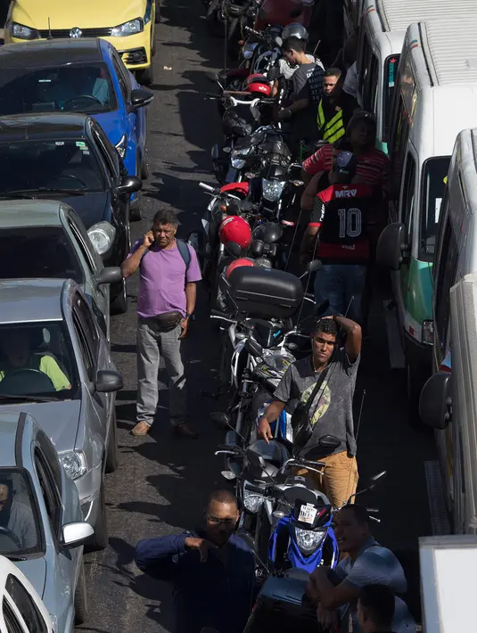 Pemandangan saat pengendara sepeda motor dan mobil mengantre BBM di salah satu SPBU di Rio de Janeiro, Brasil, Senin (28/5). Akibat mogok kerja sopir truk, Presiden Brasil Michel Temer akhirnya menurunkan kembali harga BBM. (AP Photo/Leo Correa)