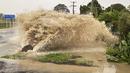 Air menyembur dari pelabuhan akses drainase badai di sebuah jalan di Te Awanga, tenggara Auckland, Selandia Baru, Selasa (14/2/2023).  Sebelumnya, Selandia Baru mengumumkan status keadaan darurat nasional saat pandemi COVID-19 dan serangan teror Christchurch. (Warren Buckland/Hawkes Bay Today via AP)