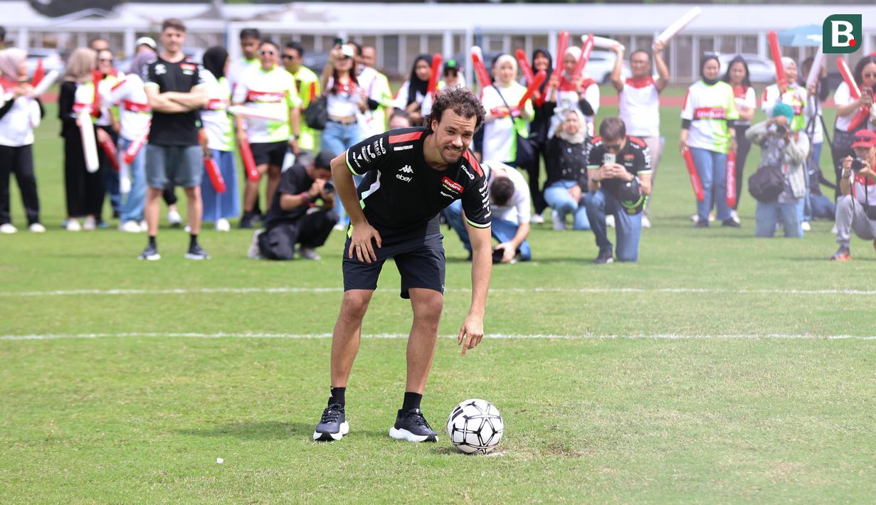 Franco Morbidelli saat menerima tantangan dalam acara football challenge Pembalap Pertamina Enduro di Stadion Madya, Senayan, Jakarta pada Jumat, (24/1/2025).  (Bola.com/Abdul Aziz)