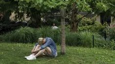 Seorang pria duduk di tempat teduh saat siang hari yang panas di Washington Square Park di New York City (17/7/2019). Panas terik bergerak ke daerah Kota New York, dengan suhu yang diperkirakan akan mencapai 100 derajat pada akhir pekan ini.  (AFP Photo/Drew Angerer)