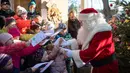 Seorang pria berpakaian Santa Claus disambut anak-anak selama pembukaan kantor surat Natal yang paling terkenal di Himmelpfort, Kamis (14/11/2019). Seperti tahun-tahun sebelumnya pada Natal kali ini Santa Klaus di Jerman sangat sibuk. (Soeren Stache/dpa via AP)