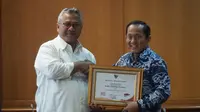 Ketua KPU RI Arief Budiman memberikan piagam penghargaan kepada ITB yang diterima rektor Kadarsah Suryadi. (Liputan6.com/Huyogo Simbolon)