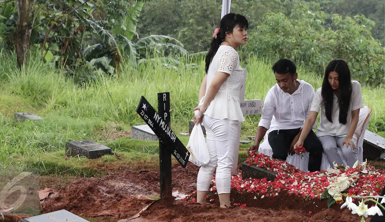 Artis Ruben Onsu didampingi Sarwenda menabur bunga di atas makam sang ayah, Johannes Abraham Onsu di TPU Pondok Ranggon, Jakarta Timur, Rabu (1/2). Ayah Ruben dan Jordi Onsu menghempuskan napas pada usia 74 tahun (Liputan6.com/Herman Zakharia)
