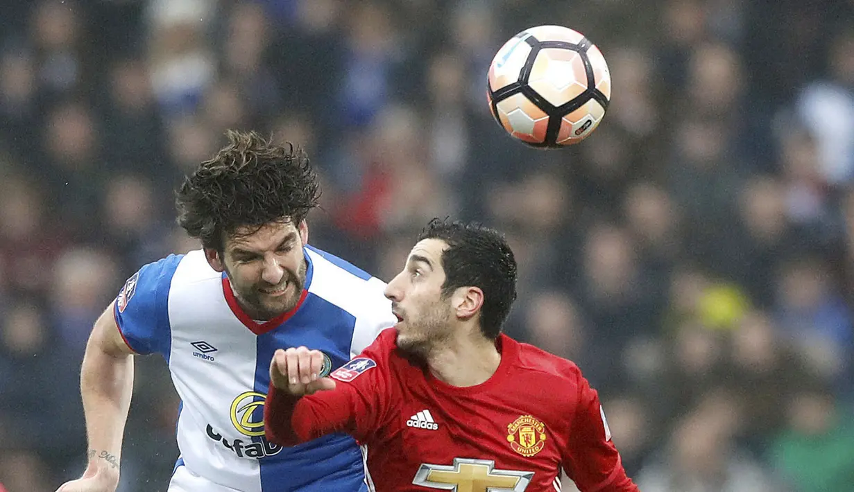 Duel pemain Blackburn Rovers, Charlie Mulgrew (kiri) dan pemain Manchester United, Henrikh Mkhitaryan pada putaran kelima Piala FA di Ewood Park, Blackburn, (19/2/2017). MU menang 2-0. (Martin Rickett/PA via AP)