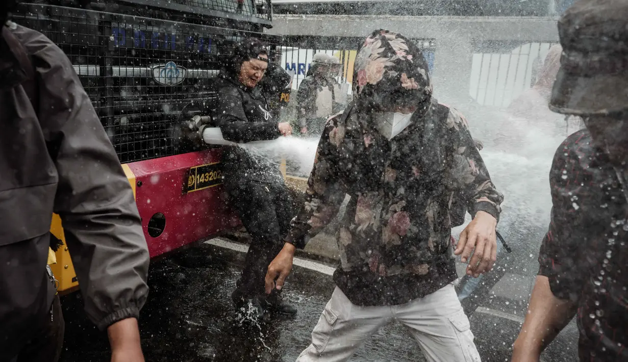 Pihak kepolisian yang berjaga berusaha membubarkan massa tersebut dengan menembakkan gas air mata ke arah pengunjuk rasa. (YASUYOSHI CHIBA/AFP)