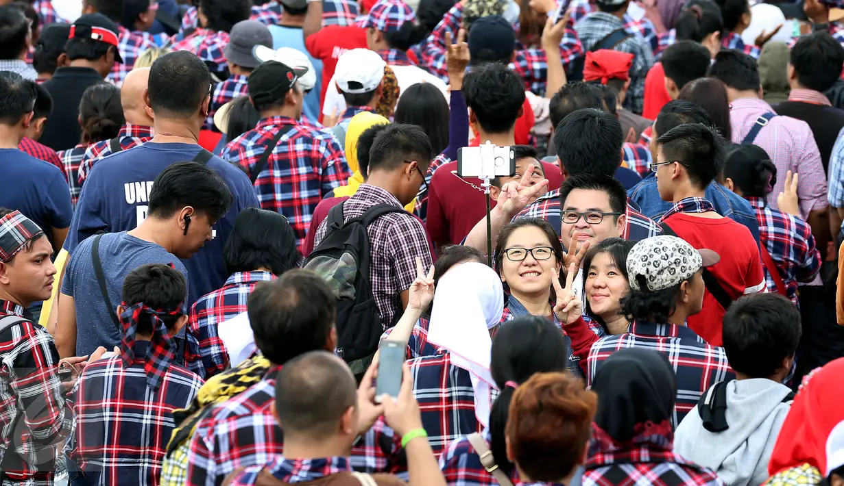 Pendukung Ahok - Djarot terlihat berselfie saat menghadiri konser gue 2 Kawasan Senayan, Jakarta, Sabtu (4/2). Sejumlah artis ikut meramaikan konser ini untuk mendukung pasangan calon nomer 2 Ahok - Djarot. (Liputan6.com/Johan Tallo)