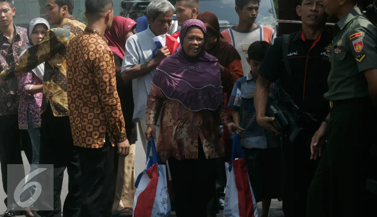 Warga membawa semboko dari Presiden Jokowi saat open house di Istana Kepresidenan Gedung Agung, Yogyakarta, Sabtu (9/7). Open House ini diikuti oleh ribuan masyarakat yang berada di Yogyakarta. (Liputan6.com/Boy Harjanto)