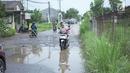 Pengendara sepeda motor melintasi jalan yang rusak di Jalan Raya Gas Alam, Depok, Jawa Barat, Selasa (7/5). Kondisi jalan yang tidak kunjung diperbaiki tersebut menjadi kubangan air setiap hujan serta berbahaya bagi keselamatan pengguna jalan. (Liputan6.com/Immanuel Antonius)
