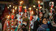 Warga mengikuti pawai obor menyambut Ramadan di kawasan Matraman Dalam, Jakarta, Minggu (27/3/2022). Pawai obor tersebut juga digelar untuk meningkatkan silaturahmi dan ukhuwah sesama umat Muslim serta menyemarakkan syiar Islam di Ibu Kota. (Liputan6.com/Faizal Fanani)