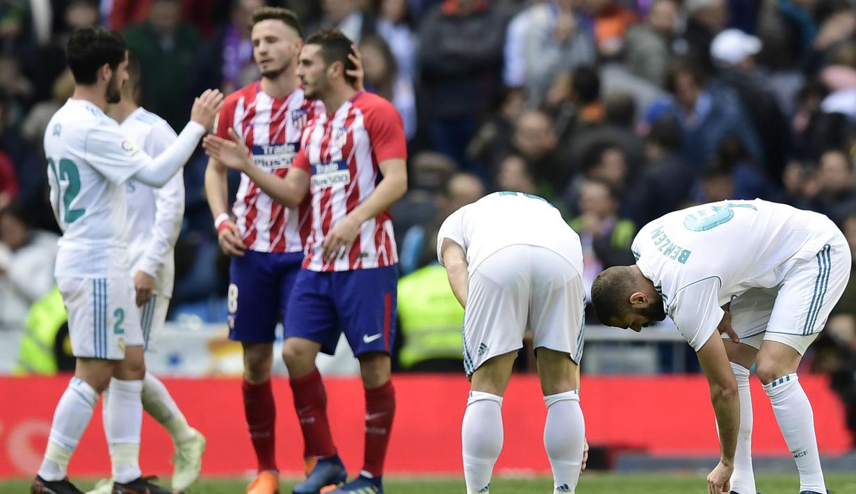 Para pemain Real Madrid tampak kecewa usai ditahan imbang Atletico Madrid pada laga La Liga Spanyol di Stadion Santiago Bernabeu, Madrid, Minggu (8/4/2018). Kedua klub bermain imbang 1-1. (AFP/Gabriel Bouys)