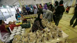 Sejumlah warga mengantri untuk mendapatkan nasi bungkus jelang buka puasa di Masjid Kauman,Yogyakarta, Senin (6/6).Takjil buka puasa di Masjid Kauman menjadi tradisi selama Ramadan setiap tahun. (Liputan6.com/Boy Harjanto)